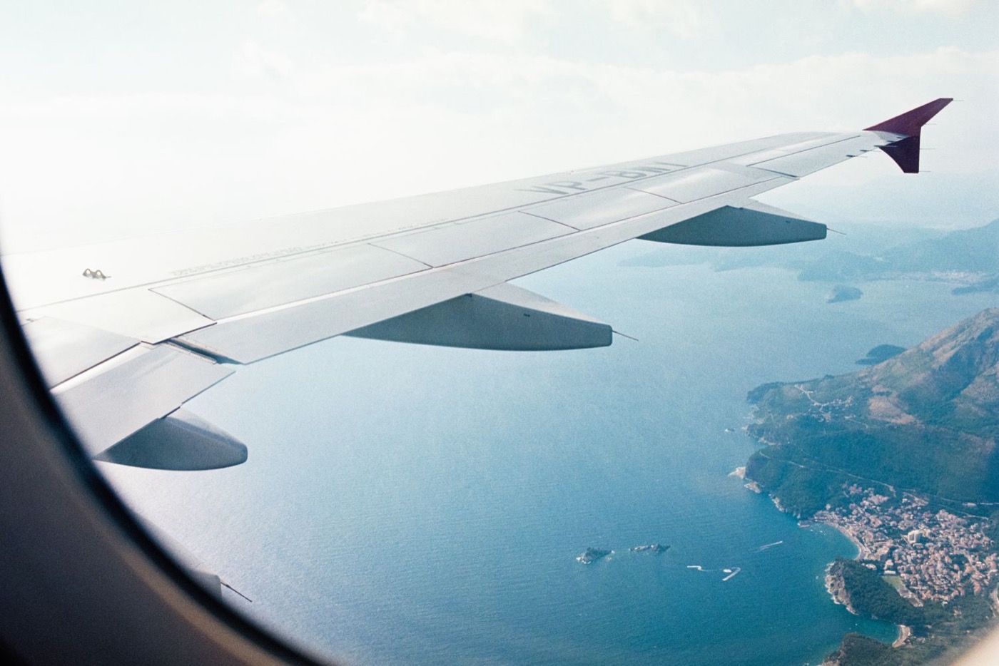 Blick aus dem Flugzeug auf Inseln im Meer – Reisekompetenz für Unternehmen