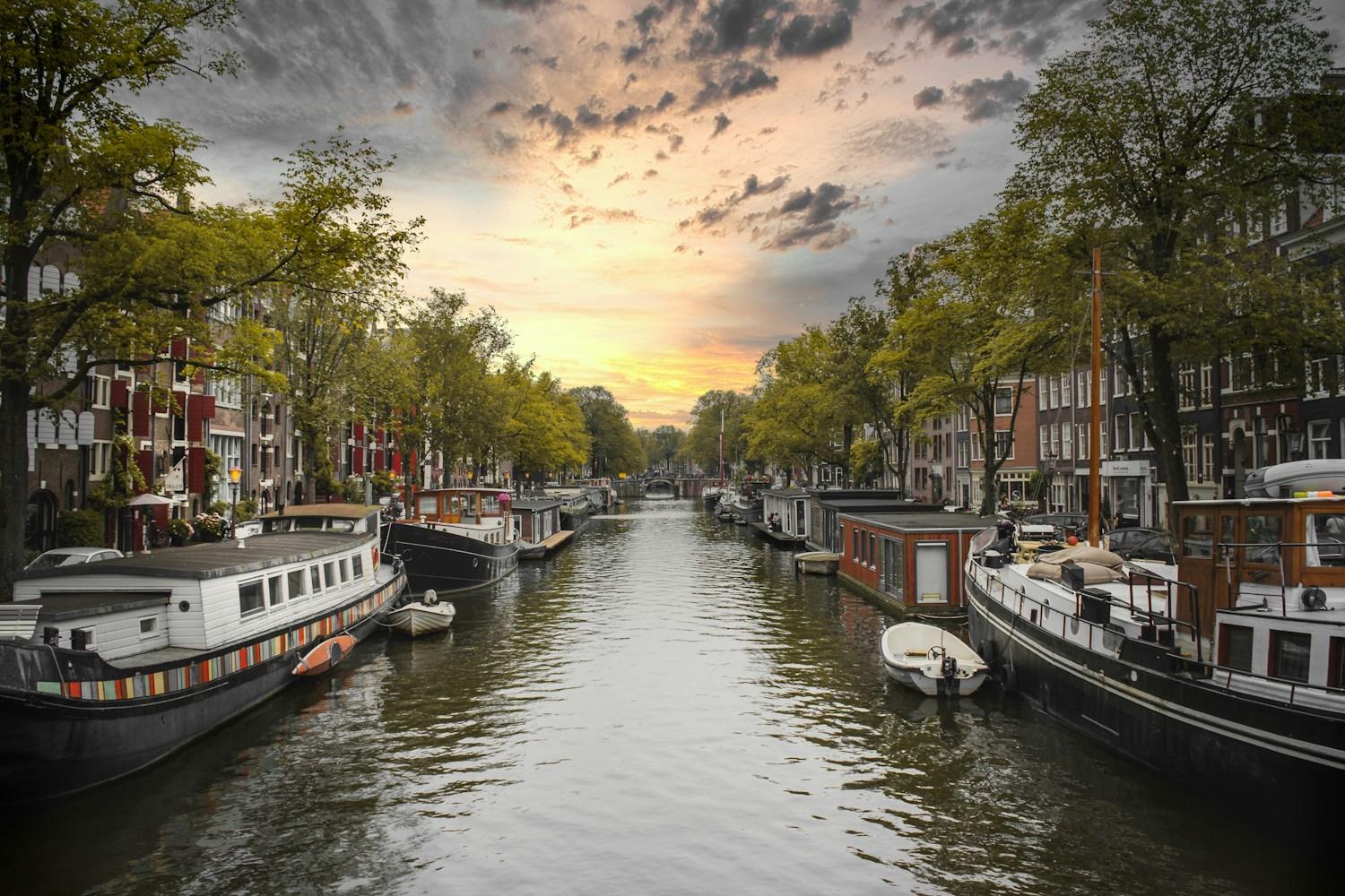 Betriebsausflug ins Ausland – Gracht mit Booten im Abendlicht