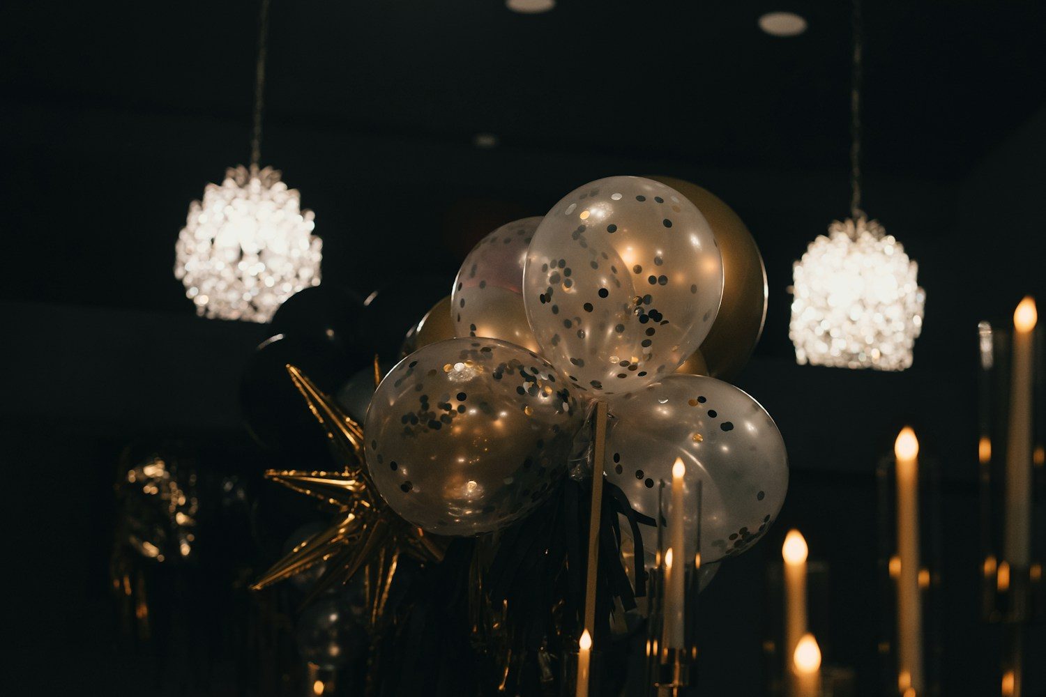Firmenjubiläum-Ideen – Gold-Ballons mit Konfetti unter Kronleuchtern