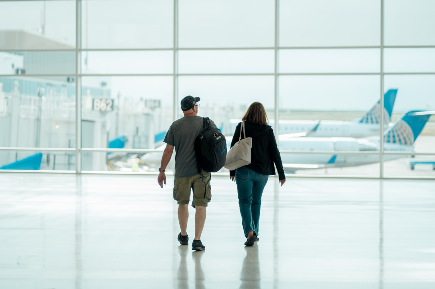 Firmenreisen – zwei Reisende am Flughafen-Gate