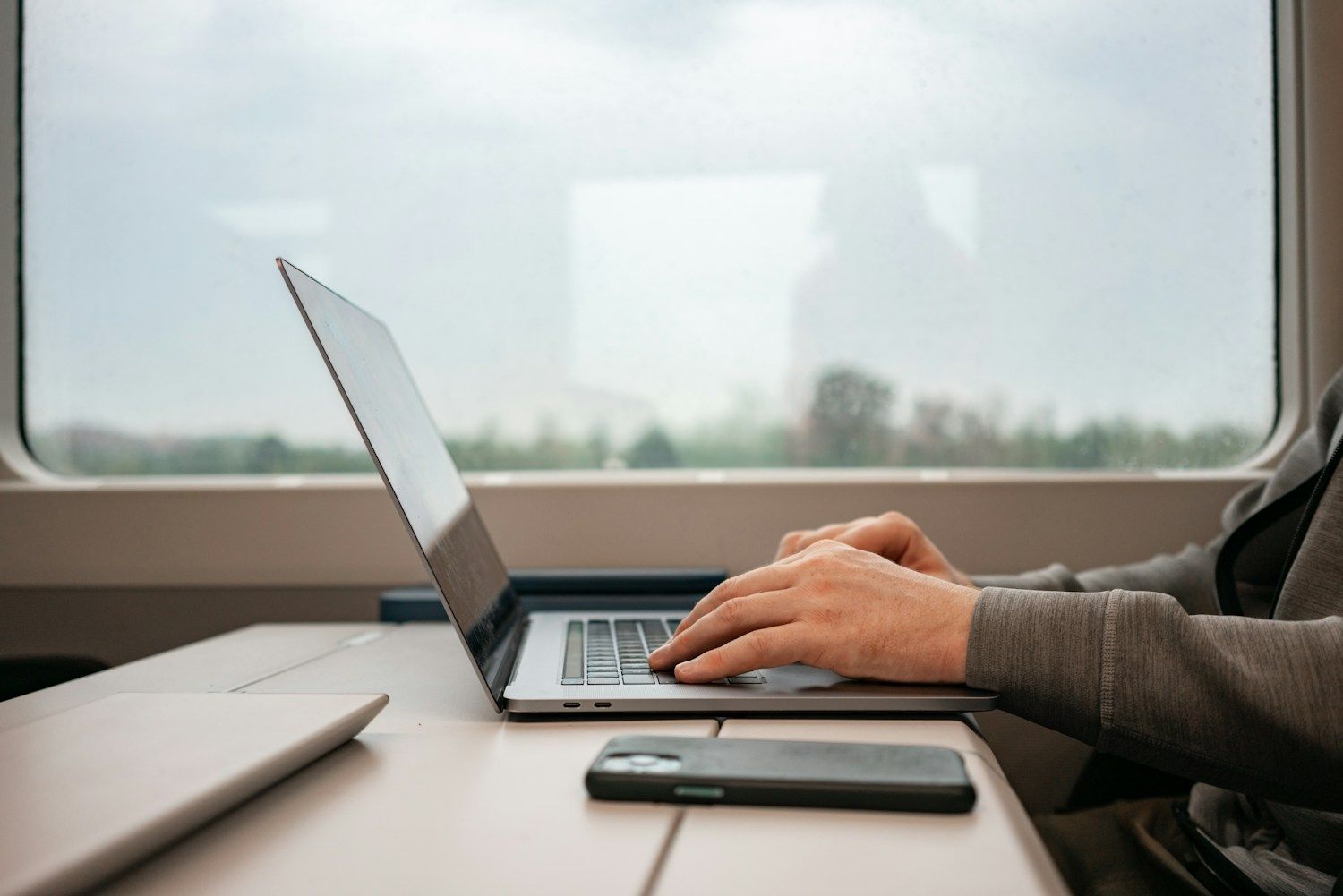 Geschäftsreise online buchen – Laptop-Arbeit am Fensterplatz im Zug