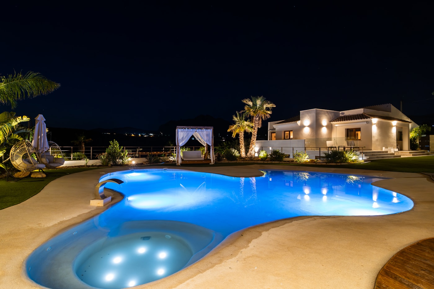 Hotel-Buy-out – private Villa mit beleuchtetem Pool am Abend