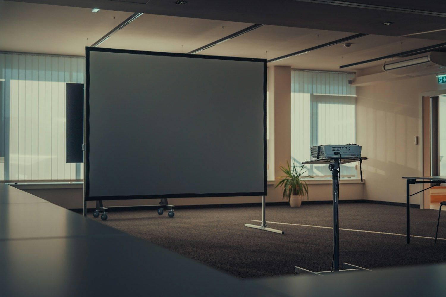 Hybride Veranstaltung – Tagungsraum mit Leinwand und Projektor