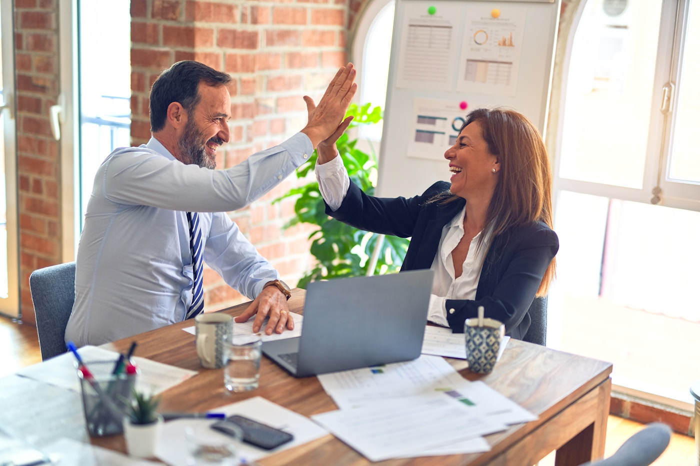Incentive-Reisen für Arbeitnehmer – Kollegen feiern einen Erfolg mit High-Five