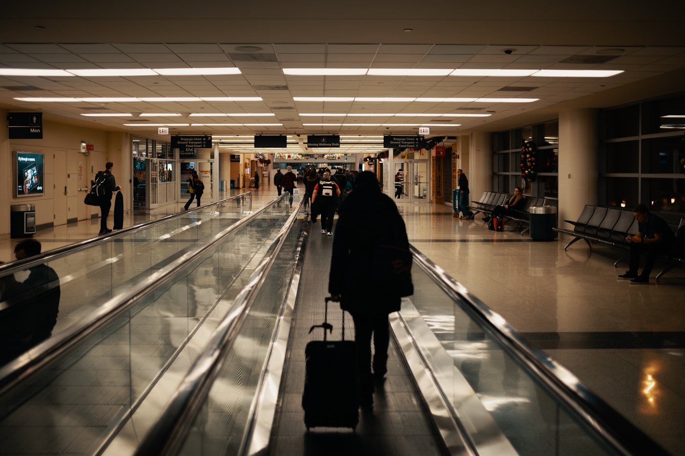 Reisekosten senken – Geschäftsreisender mit Koffer am Flughafen