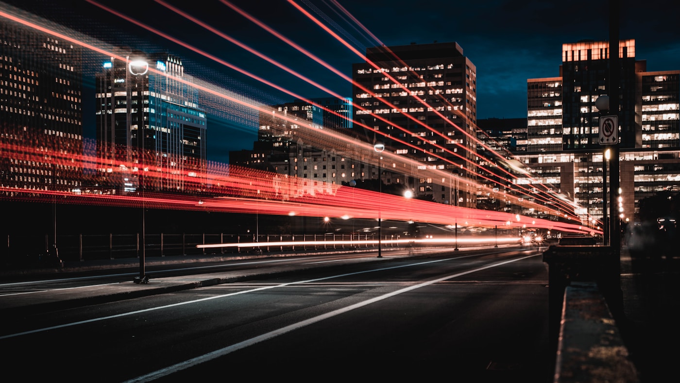 Roadshow organisieren – Straße mit Lichtspuren vor Skyline