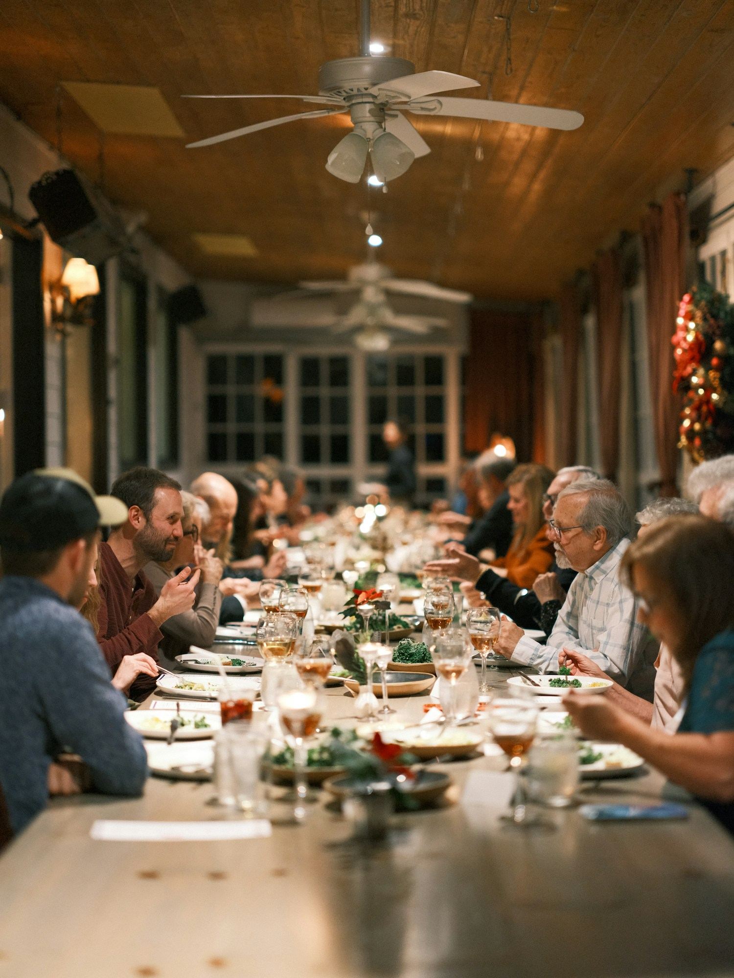 Weihnachtsfeier organisieren lassen – festlich gedeckte lange Tafel im Kerzenlicht